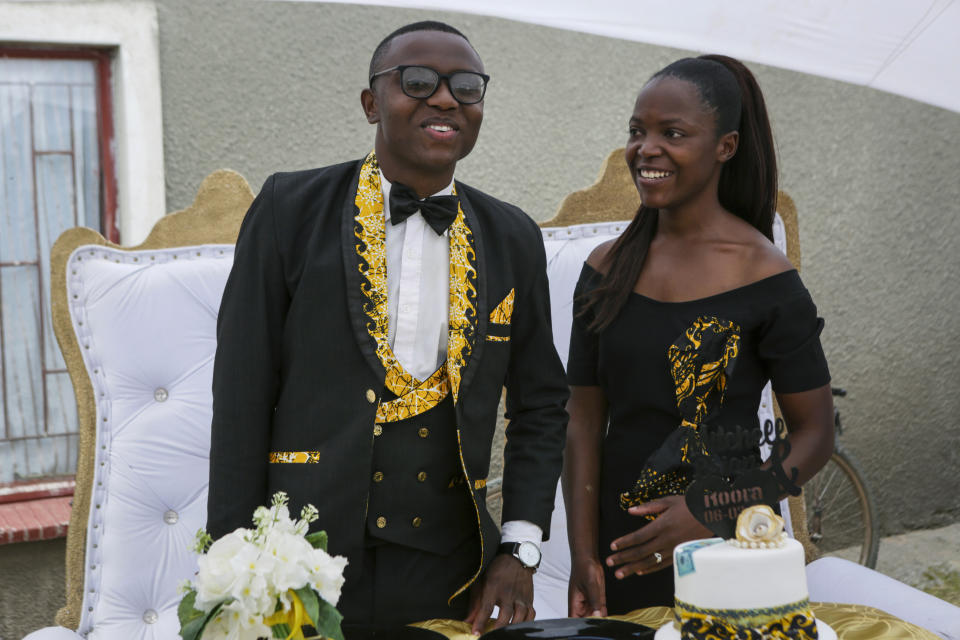 Brian Ngona, left, and Mitchelle Musaraure, pose for a photo after their traditional marriage ceremony in the capital Harare, Zimbabwe Saturday, March 6, 2021. Many people across Africa are rethinking big, bountiful weddings amid the economic ravages of COVID-19 and the coronavirus pandemic is forcing change in communities where family can mean a whole clan and weddings are seen as key in cementing relations between communities. (AP Photo/Tsvangirayi Mukwazhi)