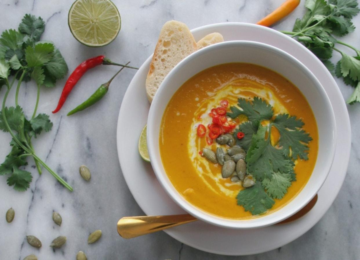 Bowl of pumpkin ginger soup with garnish.