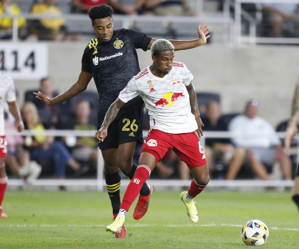 New York Red Bulls defender Kyle Duncan, right, controls the ball in front of Columbus Crew defender Saad Abdul-Salaam (26) during the first half of an MLS soccer match in Columbus, Ohio, Tuesday, Sept. 14, 2021. (AP Photo/Paul Vernon)