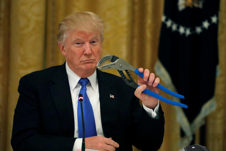 Trump holds a mechanical tool as he attends a Made in America roundtable in the East Room of the White House on July 19.