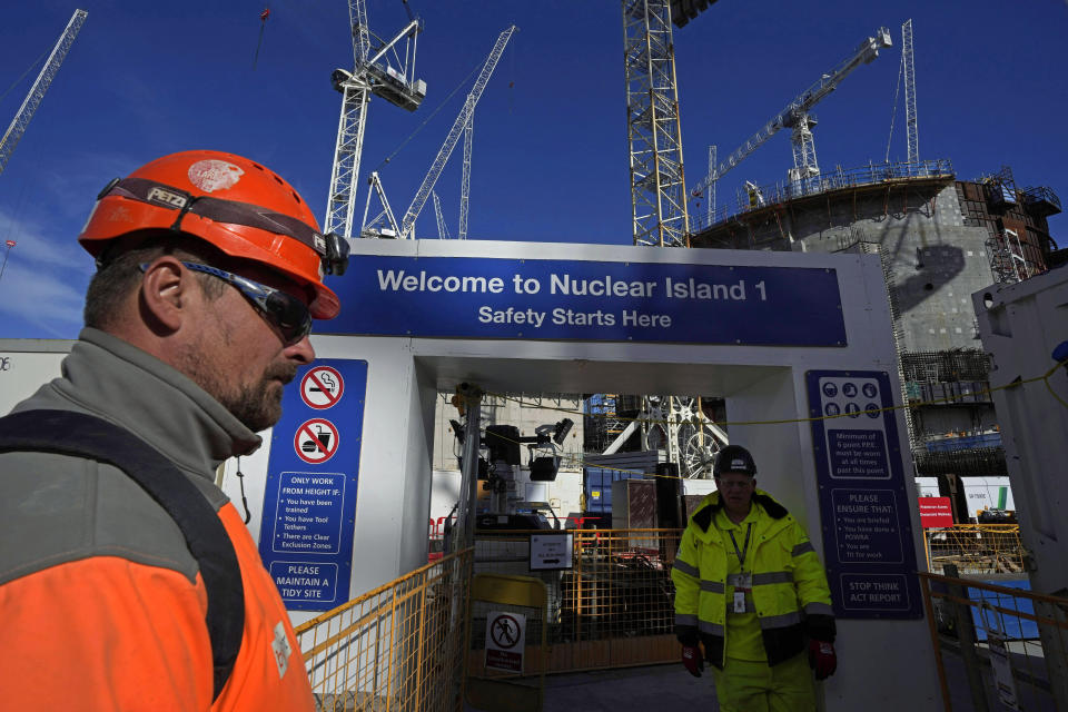 Employees work at the construction site of Hinkley Point C nuclear power station in Somerset, England, Tuesday, Oct. 11, 2022. Nuclear power is generated through fission, the process of splitting uranium atoms. The energy released by fission turns water into steam to spin a turbine that generates electricity, a process which doesn’t emit planet-warming gases into the atmosphere. (AP Photo/Kin Cheung)