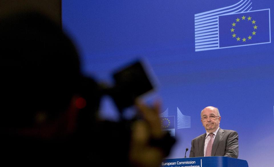 European Commissioner for Competition Joaquin Almunia, right, grimaces during a media conference at EU headquarters in Brussels on Monday, Jan. 13, 2014. The European Union's antitrust watchdog says it has opened an investigation on licensing agreements between several major U.S. film studios and European pay TV broadcasters. Its probe covers Twentieth Century Fox, Warner Bros., Sony Pictures, NBCUniversal and Paramount Pictures. (AP Photo/Virginia Mayo)