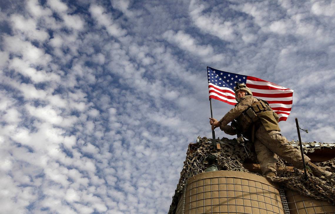 LCpl John Westwood gets instructions from a fellow Marine on the ground as he puts the finishing touches on the American flag he planted at the main gate of FOB Hassanbad which Golf Company of the 2/2 calls home in the Helmand Province of Afghanistan.He said aftererecting the flag, “I was putting up the American flag and the Afghan flag and I felt all the honor in the world to be able to do something like that , to put up our flag in a foreign country I think was a great deal. When I was finished putting those flags up...the words couldn’t...can’t express the way it made me feel.