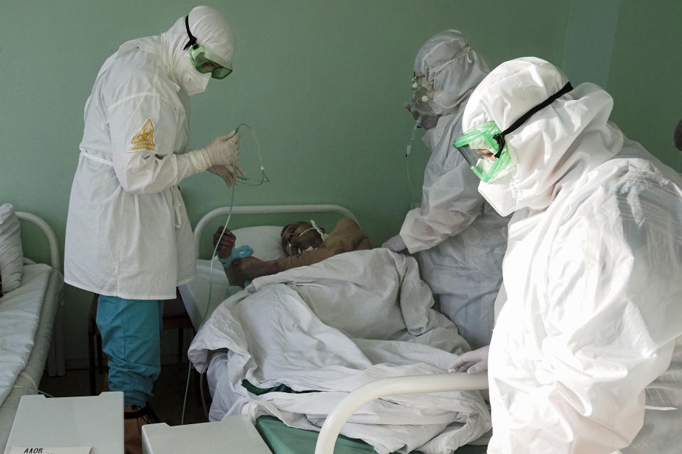 Medical workers treat a coronavirus patient in a COVID-19 unit of a hospital in Sortavala, Karelia region, Russia, Tuesday, Feb. 16, 2021. Russia’s rollout of its coronavirus vaccine is only now picking up speed in some of its more remote regions, although experts say the campaign is still moving slowly. (AP Photo/Dmitri Lovetsky)