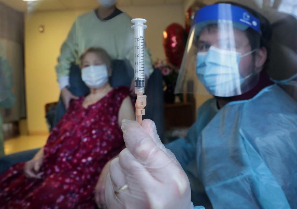 A CVS Pharmacy employee holds the syringe he used to vaccinate resident Beverly Berger for COVID-19  Monday, December 28, 2020 at the Markesan Resident Home in Markensan, Wis.