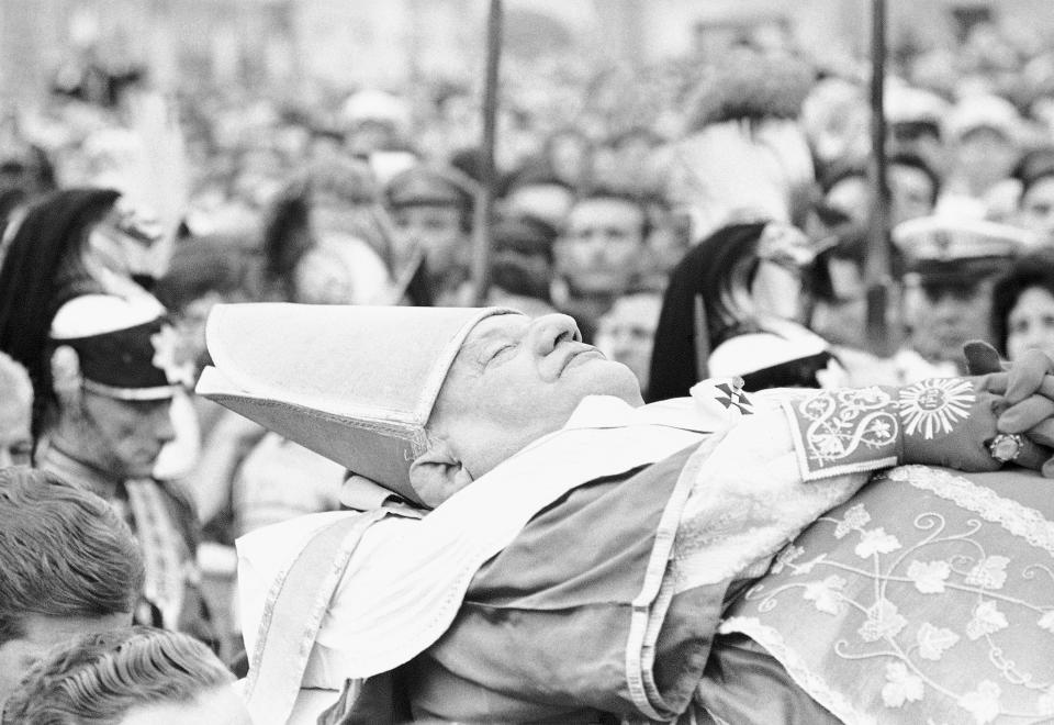 FILE - In this June 4, 1963 file photo the body of late Pope John XXIII is carried across St. Peter's Square, from the papal apartment in the Apostolic palace to St. Peter's Basilica where it will lie in state at the main altar. While much of the focus of Sunday's dual canonization will be on Pope John Paul II's globe-trotting, 26-year papacy and his near-record sprint to sainthood, many older Catholics will be celebrating the short but historic pontificate of the "Good Pope," John XXIII. (AP Photo/File)