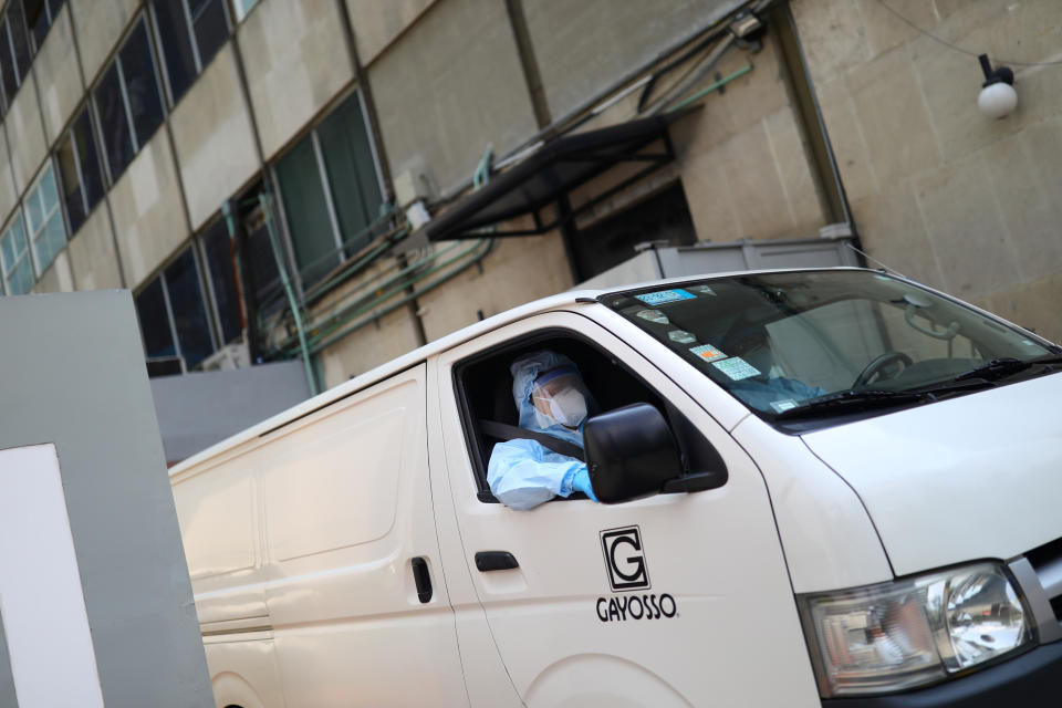 Employees of Funeral Gayosso wearing protective clothing drive a vehicle while they go to transport a deceased person, as the outbreak of the coronavirus disease (COVID-19) continues in Mexico City, Mexico May 11, 2020. Picture taken May 11, 2020. REUTERS/Edgard Garrido