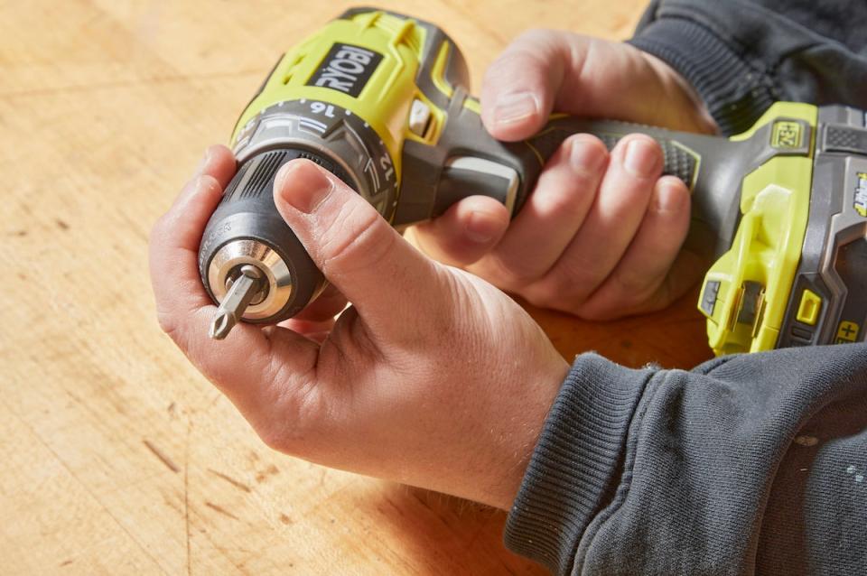 Handyperson inserts a new bit into a cordless drill. 