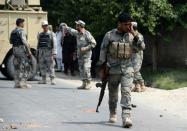 Afghan security forces inspect the site of a remote-controlled bomb blast that targeted a police checkpoint in Jalalabad on July 25, 2015