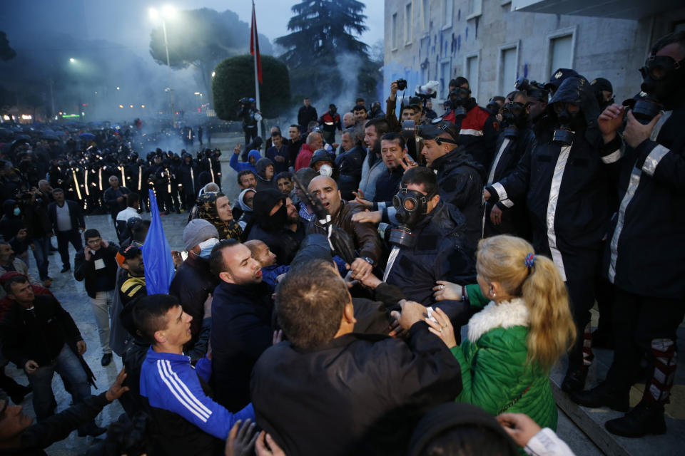 Opposition protesters scuffle with police during an anti-government rally in Tirana, Albania, Saturday, April 13, 2019. Albanian opposition parties have gathered supporters calling for the government's resignation and an early parliamentary election. (AP Photo/Visar Kryeziu)