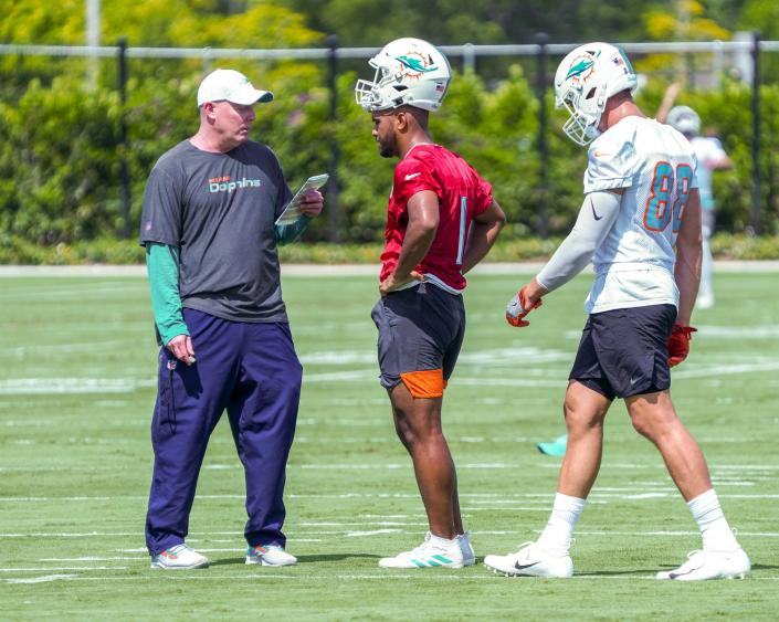Co-Offensive Coordinator George Godsey instructs quarterback Tua Tagovailoa (1) and tight end Mike Gesicki (88) during practice at Miami Dolphins training camp, July 28, 2021.
