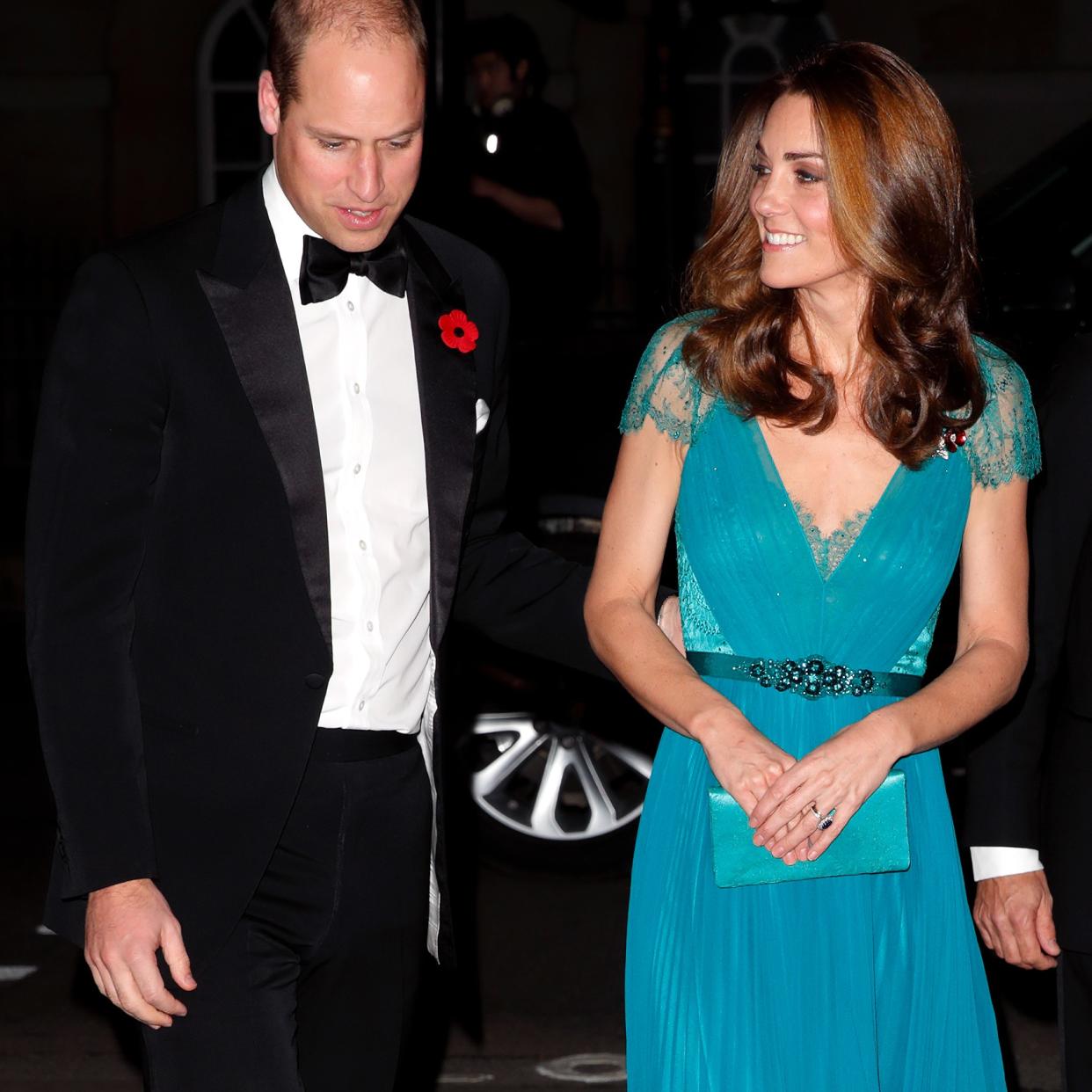  Prince William puts a hand on the small of Kate Middleton's back at a gala. 