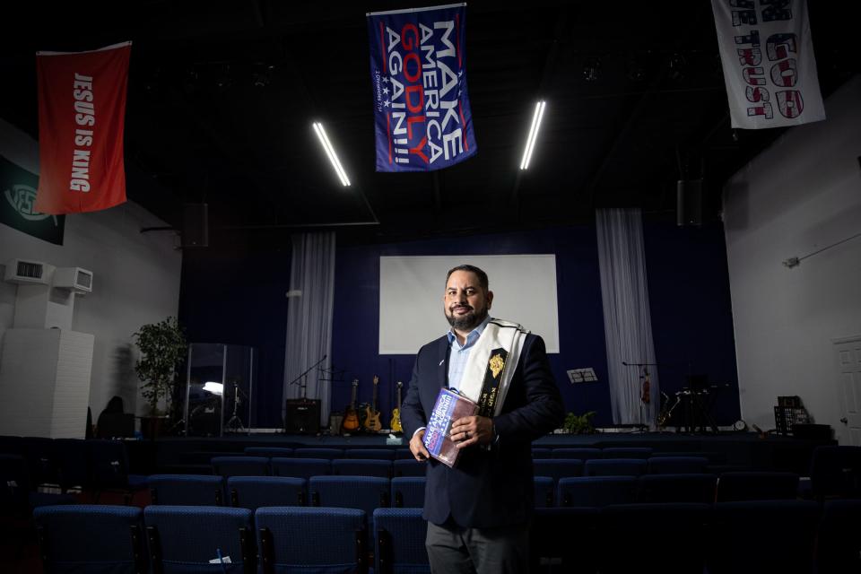 Luis Cabrera, 44, founding pastor of City Church Harlingen, holds a Bible with a sticker on the leather-bound jacket reading, “Make America Godly Again,” in his church on Oct. 6 in Harlingen, Texas.