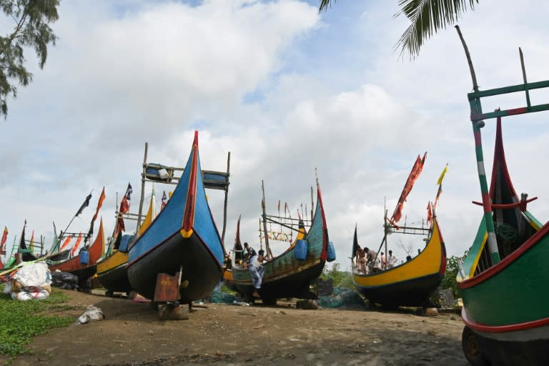 Bangladeshi fishermen work on their boats near Teknaf