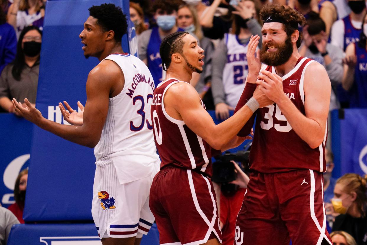 OU's Tanner Groves (35) reacts to a foul call as Jordan Goldwire (0) pats him on the chest while Kansas forward David McCormack (33) responds to the referee during the Jayhawks' 71-69 win Saturday at Allen Fieldhouse in Lawrence, Kan.