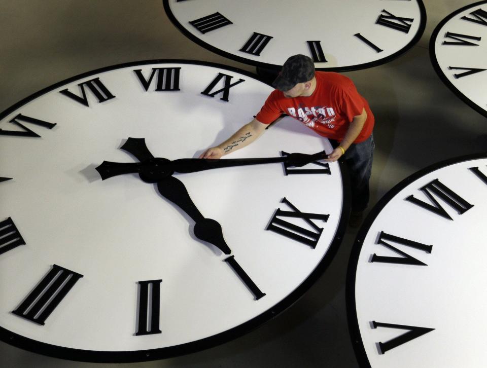 In this Thursday, Nov. 3, 2016 photo, Dan LaMoore sizes hands for an 8-foot diameter silhouette clock at Electric Time Co., in Medfield, Mass. Daylight saving time ends at 2 a.m. local time Sunday, when clocks are set back one hour. (AP Photo/Elise Amendola)