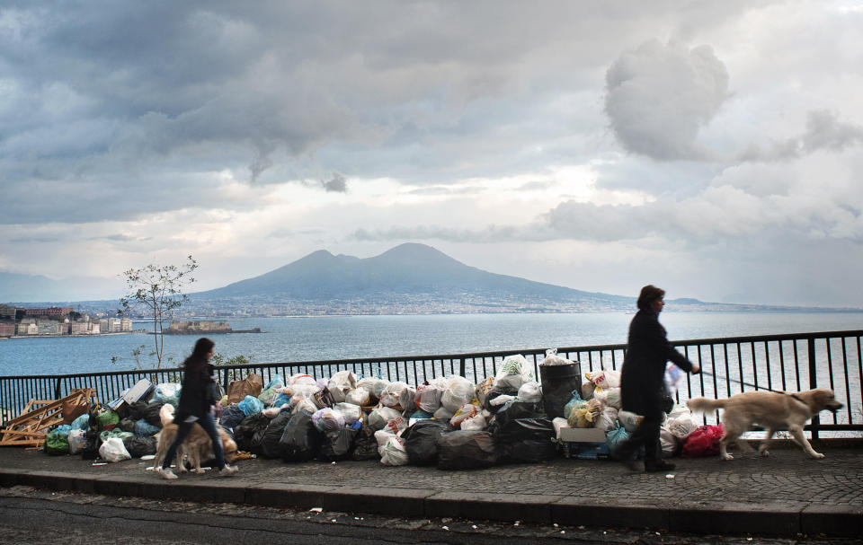 FILE - People walk past uncollected trash in Naples, Italy, on Nov. 22, 2010. The European Court of Human Rights has found Italy violated the human rights of residents living in and around Naples by failing to manage a 15-year garbage and pollution crisis. The verdict announced Thursday, Oct. 19, 2023 is the second major one in recent years finding that Italy’s failure to collect, treat and dispose of tons of waste in the Campania region adversely affected residents’ personal well-being. (AP Photo/Salvatore Laporta, File)