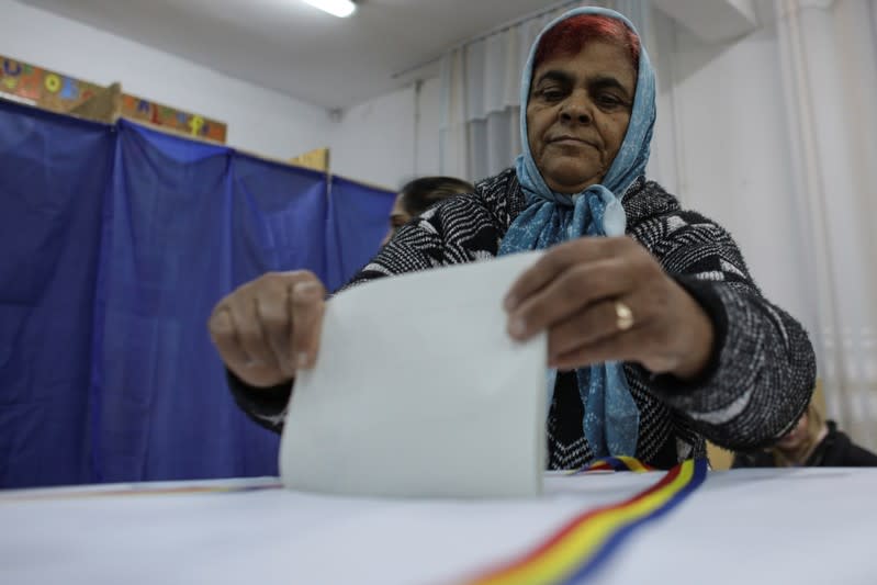 A Romanian casts her vote during the second round of a presidential election, in Frumusani