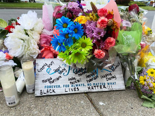 Flowers left outside of Tops Friendly Market and a sign with the names of the 10 people who were killed in what authorities have described as a “racially-motivated” shooting at a Buffalo, New York, on May 14. (Photo: Phillip Jackson/HuffPost)