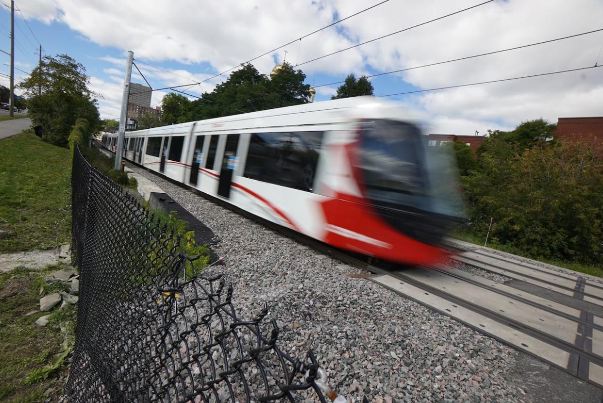 An LRT train speeds along the Confederation Line in 2020. This month marks four years since the line's launch, and it's far from the 'world-class transit system' politicians promised the day the line opened. (Francis Ferland/CBC - image credit)