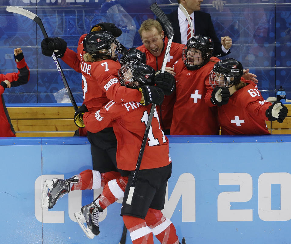 Lara Stalder of Switzerland is greeted at the bench after scoring against Russia during the 2014 Winter Olympics women's ice hockey quarterfinal game at Shayba Arena, Saturday, Feb. 15, 2014, in Sochi, Russia. Switzerland defeated Russia 2-0. (AP Photo/Matt Slocum)