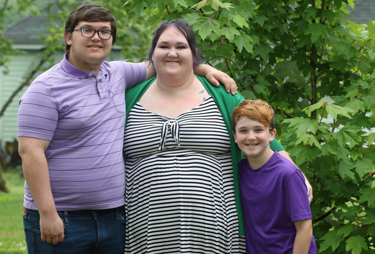 Noah Miller, Malory Chapman and Nick Guthrie pose together outside thier home on Richard Street in Lawndale Saturday morning, May 4, 2024.