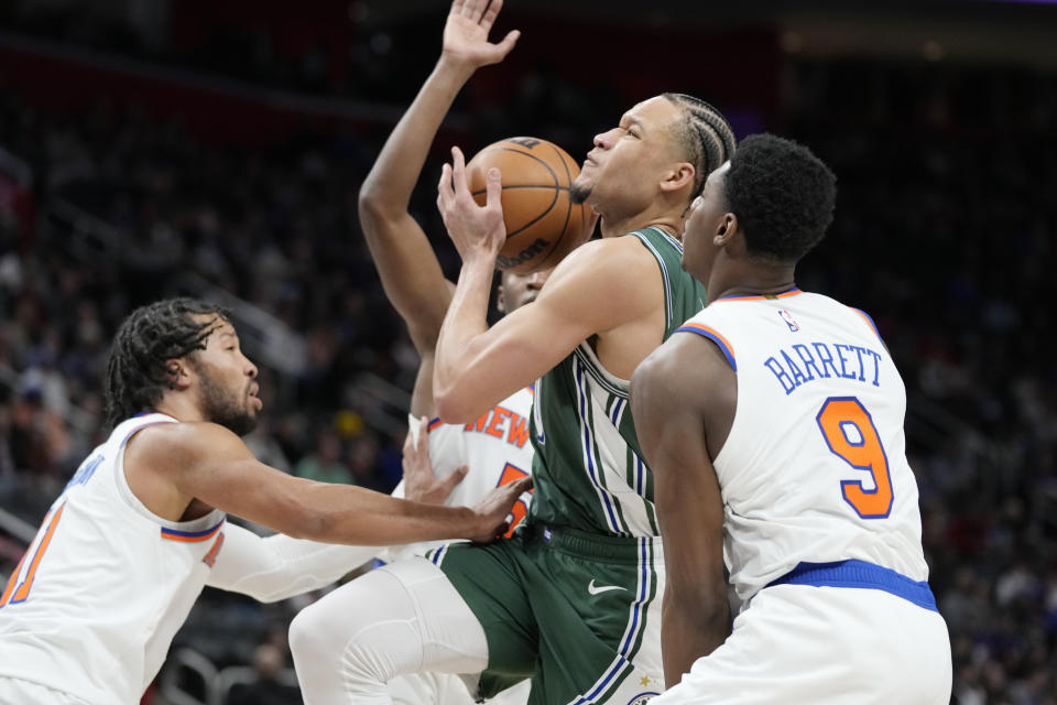 Detroit Pistons forward Kevin Knox II (20) drives between New York Knicks guards RJ Barrett (9) and Jalen Brunson during the first half of an NBA basketball game, Sunday, Jan. 15, 2023, in Detroit. (AP Photo/Carlos Osorio)