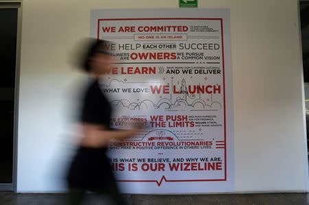 An employee of San Francisco-based software company Wizeline, walks past a sign at the company's offices in Guadalajara, Mexico October 5, 2017. Picture taken October 5, 2017. REUTERS/Daniel Becerril