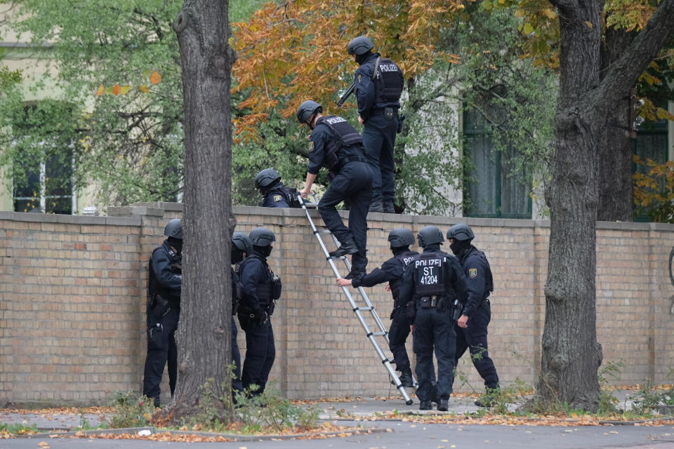 Police officers cross a wall at a crime scene in Halle, Germany, Wednesday, Oct. 9, 2019. (Photo: ASSOCIATED PRESS)