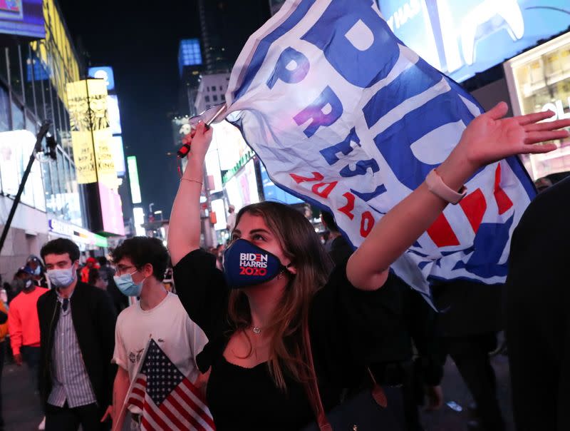 People react in New York after news media announced Democratic nominee former Vice President Joe Biden has won the 2020 U.S. presidential election