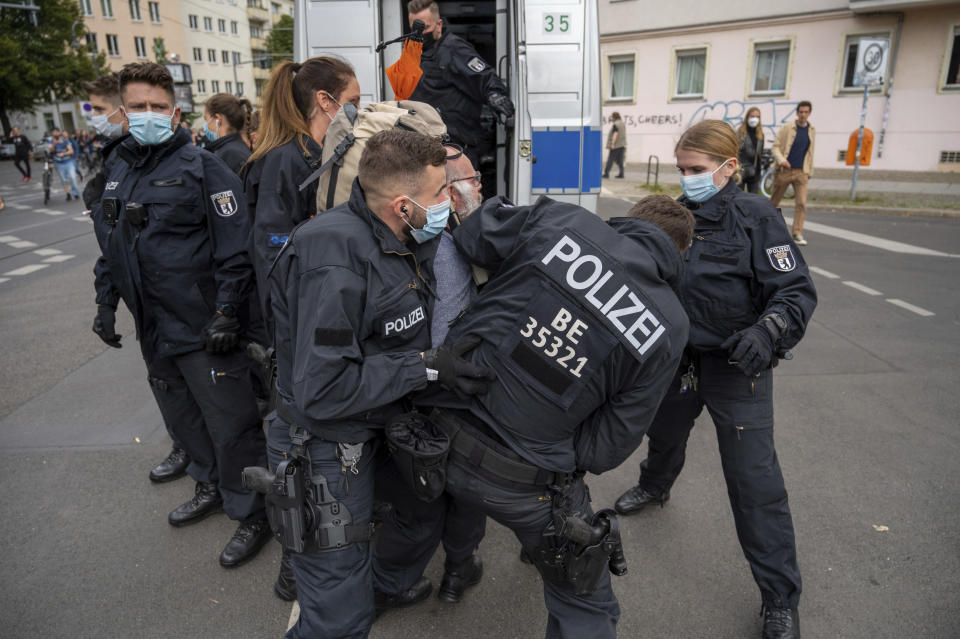 Police restrain a demonstrator, during a protest against coronavirus restrictions, in Berlin, Saturday, Aug. 28, 2021. (Christophe Gateau/dpa via AP)