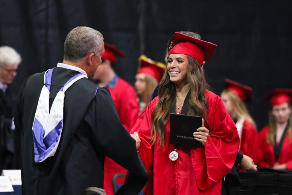 A Creekside High graduate accepts her diploma May 28, 2022, at UNF Arena in Jacksonville.