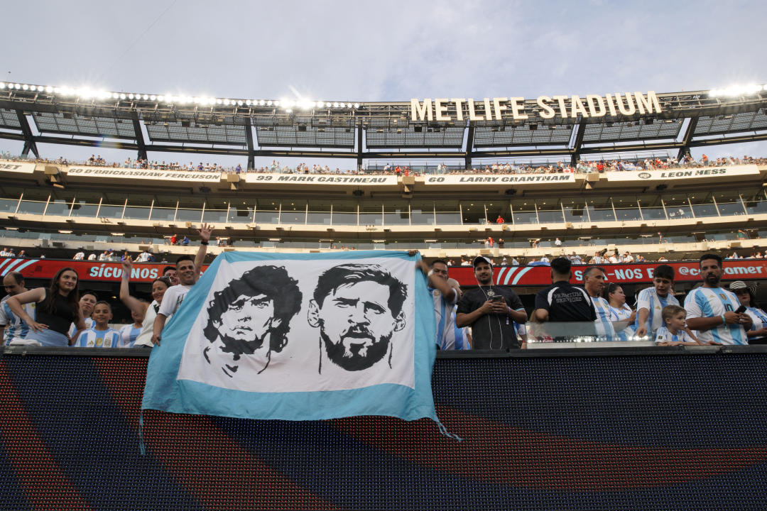 Argentine fans hold a banner with images of Argentine striker Lionel Messi (R) and late Argentine football player Diego Maradona during the semi-final football match of the Conmebol 2024 Copa América tournament between Argentina and Canada at MetLife Stadium in East Rutherford, New Jersey , on July 9, 2024. (Photo by EDUARDO MUNOZ/AFP) (Photo by EDUARDO MUNOZ/AFP via Getty Images)