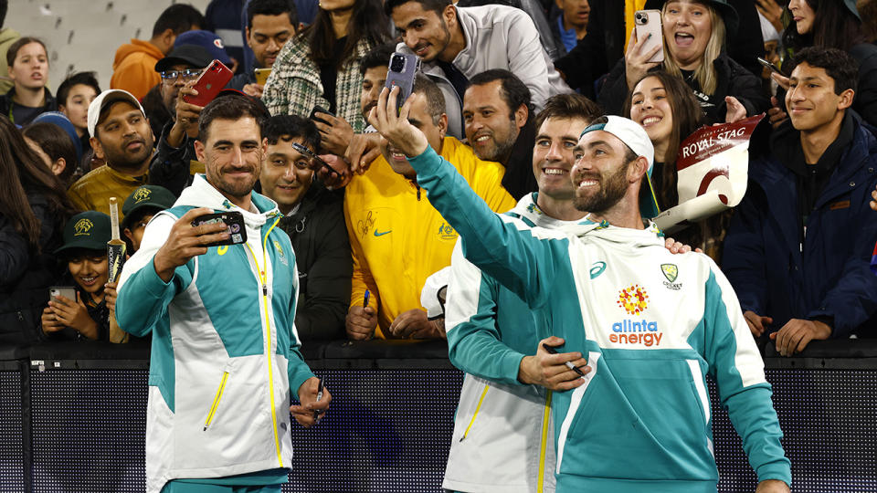Australian cricketers Mitchell Starc, Pat Cummins and Glenn Maxwell pose for photos with spectators.