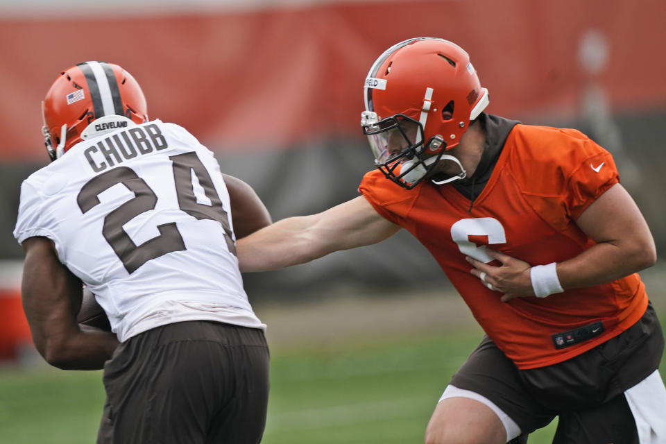 Cleveland Browns quarterback Baker Mayfield, right, hands the ball off to running back Nick Chubb during an NFL football practice, Thursday, July 29, 2021, in Berea, Ohio. (AP Photo/Tony Dejak)