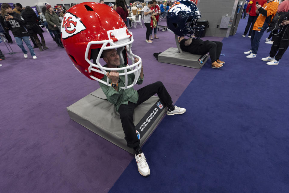 Carlos Morrellon poses with a Kansas City Chiefs helmet during NFL Experience ahead of Super Bowl 58, Saturday, Feb. 10, 2024, in Las Vegas. The Kansas City Chiefs will play the NFL football game against the San Francisco 49ers Sunday. (AP Photo/Gregory Bull)