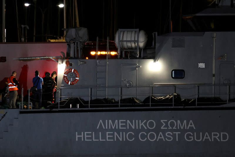 FILE PHOTO: Body bags carrying migrants who died after their boat capsized in the open sea off Greece, are seen onboard a Hellenic Coast Guard vessel at the port of Kalamata