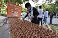 NEW DELHI, INDIA - AUGUST 4: A worker arranges diyas or earthen lamps which were distributed by BJP MP Parvesh Verma outside his official residence on the eve of the foundation stone laying in Ayodhya of the Ram Temple, on August 4, 2020 in New Delhi, India. Prime Minister Narendra Modi will on Wednesday attend a public function on laying of the foundation stone of 'Shree Ram Janmabhoomi Mandir' at Ayodhya. Ram Janmabhoomi Teerth Kshetra, the trust set up for the construction and management of Ram temple, has invited 175 eminent guests for the foundation stone-laying ceremony after personally discussing with BJP veterans L K Advani and Murli Manohar Joshi, lawyer K Parasaran and other dignitaries. (Photo by Mohd Zakir/Hindustan Times via Getty Images)