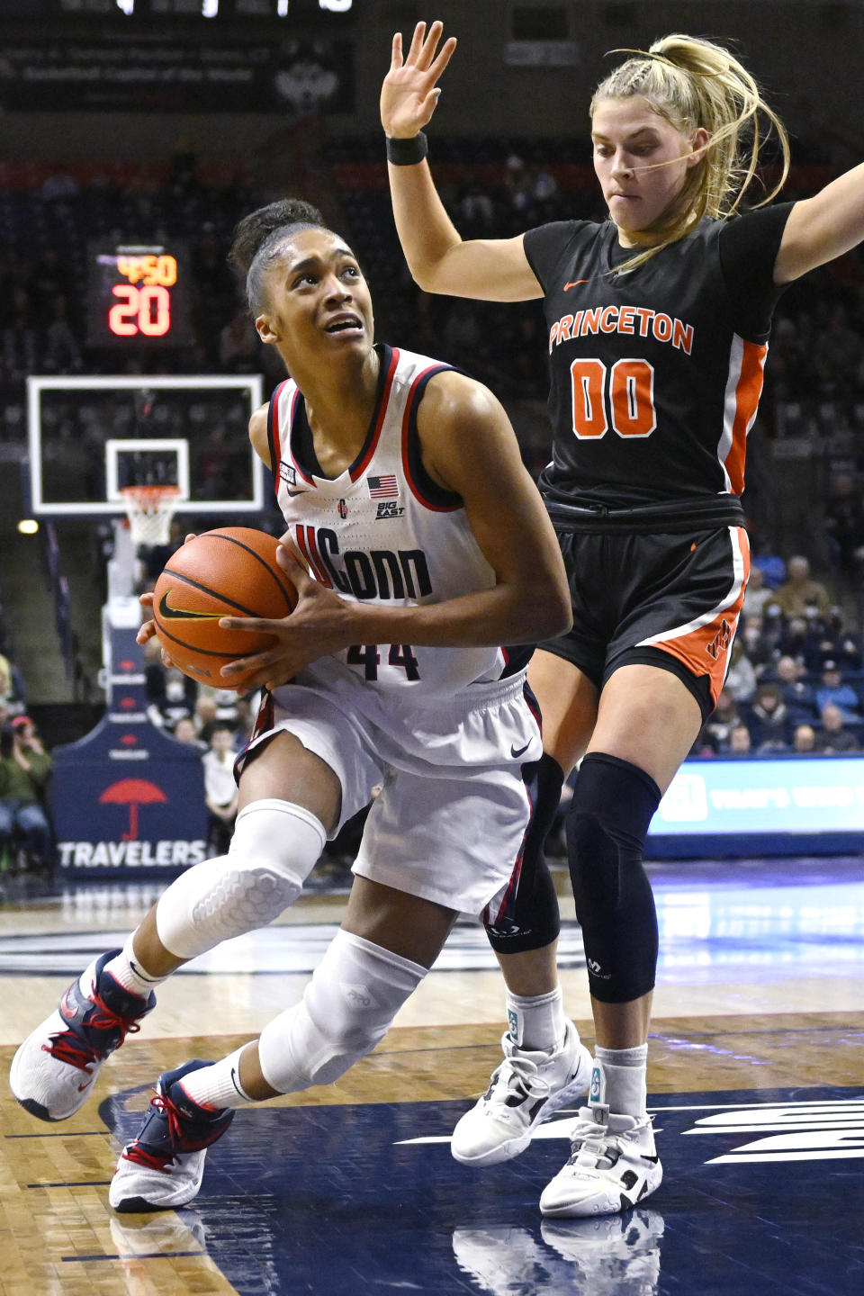 Connecticut's Aubrey Griffin (44) drives to the basket as Princeton's Ellie Mitchell (00) defends during the first half of an NCAA college basketball game Thursday, Dec. 8, 2022, in Storrs, Conn. (AP Photo/Jessica Hill)