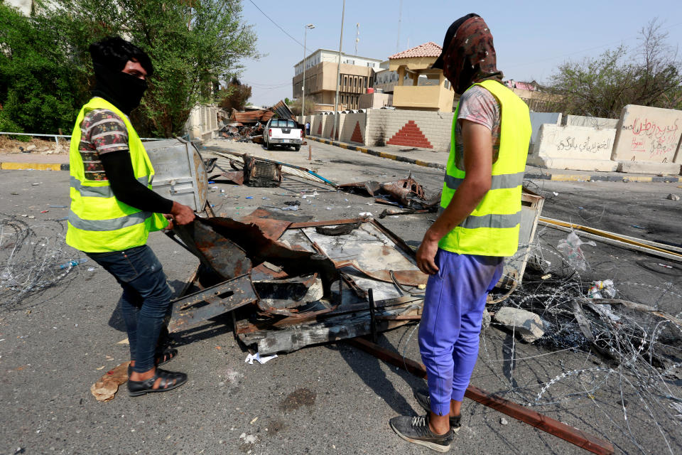 Municipal workers clean the ground near the government building in Basra