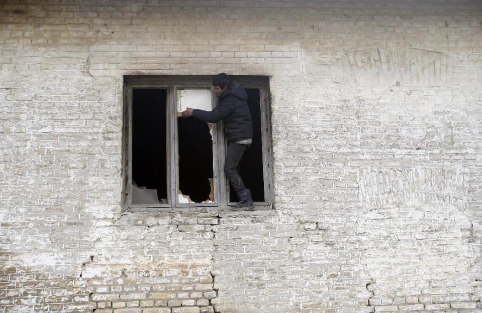 A migrant breaks a wooden board for firewood on an abandoned brick factory in the northern Serbian town of Subotica, near the border between Serbia and Hungary, Wednesday, Feb. 1, 2017. Thousands of migrants have been stranded in Serbia and looking for ways to cross illegally into the European Union. (AP Photo/Darko Vojinovic)