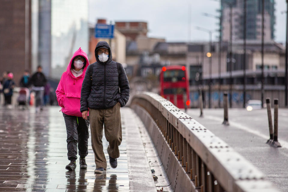 LONDON, UNITED KINGDOM - 2021/12/05: A couple wears face masks as a preventive measure against the spread of covid-19 while walking along Piccadilly road.
Health experts in the UK warn the public that Omicron variant cases will rise more than 50% in a day after Christmas. They urged the public to observe more stringent preventive measures. (Photo by Pietro Recchia/SOPA Images/LightRocket via Getty Images)