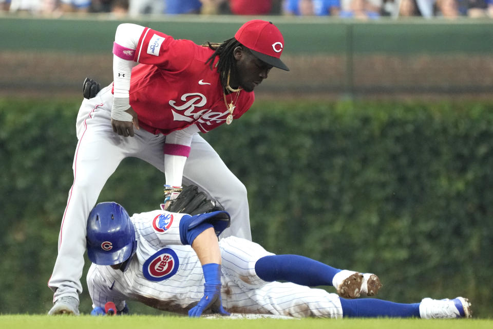 Chicago Cubs' Nico Hoerner, bottom, is safe at second base after hitting a double as Cincinnati Reds shortstop Elly De La Cruz applies a late tag during the first inning of a baseball game in Chicago, Thursday, Aug. 3, 2023. (AP Photo/Nam Y. Huh)