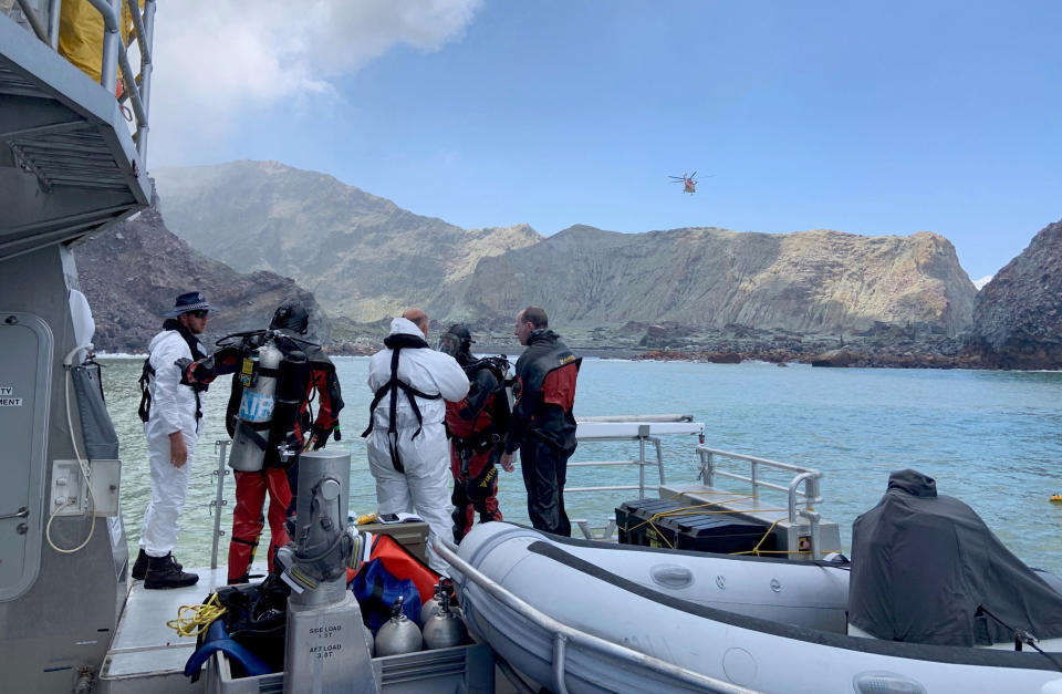 Police divers prepare to search the waters near White Island off the coast of Whakatane, New Zealand, Saturday Dec. 14, 2019. A team of nine from the Police National Dive Squad resumed their search at early Saturday for a body seen in the water following Monday's volcanic eruption. (New Zealand Police via AP)