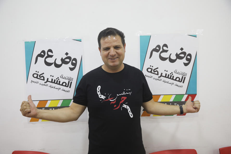 FILE - In this Aug. 29, 2019 file photo, Ayman Odeh, the leader of the Arab Joint List parties, poses for a photo in party offices in Nazareth, Israel. An unprecedented repeat election next week provides no guarantee that the do-over vote will produce a more decisive result than an inconclusive one last April. Arabic on posters reads : "The Joint List, the front, the Islamic, the change, the assembly, our unity is strength." Arabic on T-shirt reads "I breathe freedom." (AP Photo/Mahmoud Illean, File)