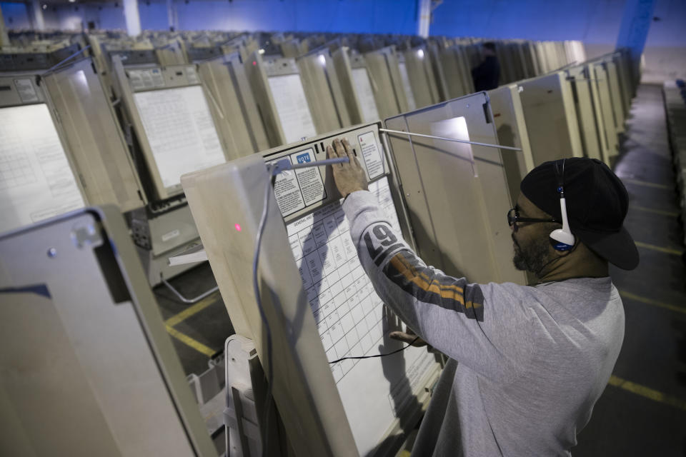 FILE- In this Oct. 14, 2016, file photo, a technician works to prepare voting machines to be used in the upcoming presidential election in Philadelphia. With the presidential primaries less than a year away, security experts and elected officials have expressed concern about whether the state and federal governments have done enough since 2016 to fend off another attack by Russia or other foreign actors. (AP Photo/Matt Rourke, File)