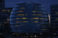 City Hall on the south bank of the Thames in London is illuminated in the evening of Saturday, March 6, 2021. (AP Photo/Alastair Grant)