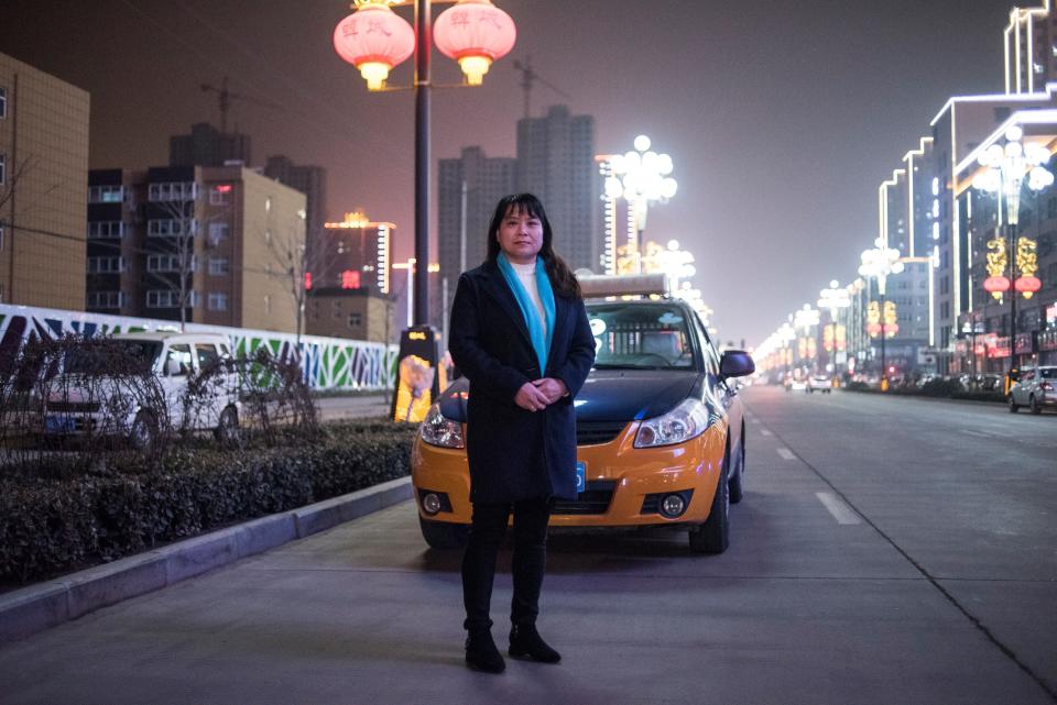 Taxi driver Yang Fengxia, 45, poses in the street in Hancheng,&nbsp;China, on&nbsp;Feb. 16, 2018.