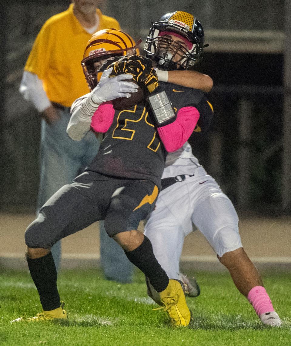 Lathriop's Kameron Jones (24) is tackled by Los Banos' Mark Carreiro (11) during a varsity football game at Lathrop on Friday, Oct. 21, 2022.