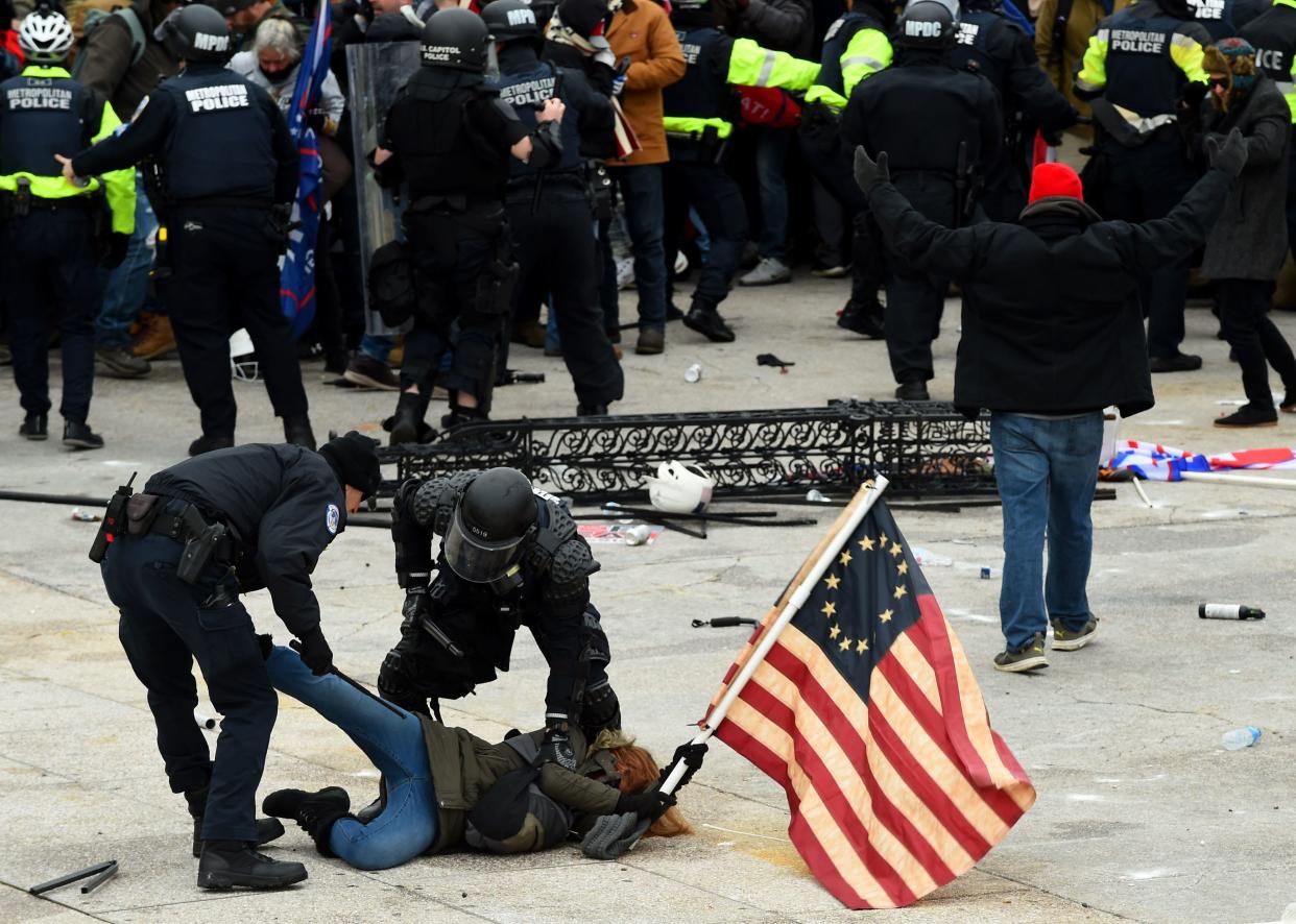 <p>File image: Police detain a person as Trump supporters riot outside the Capitol on 6 January</p> (AFP via Getty Images)